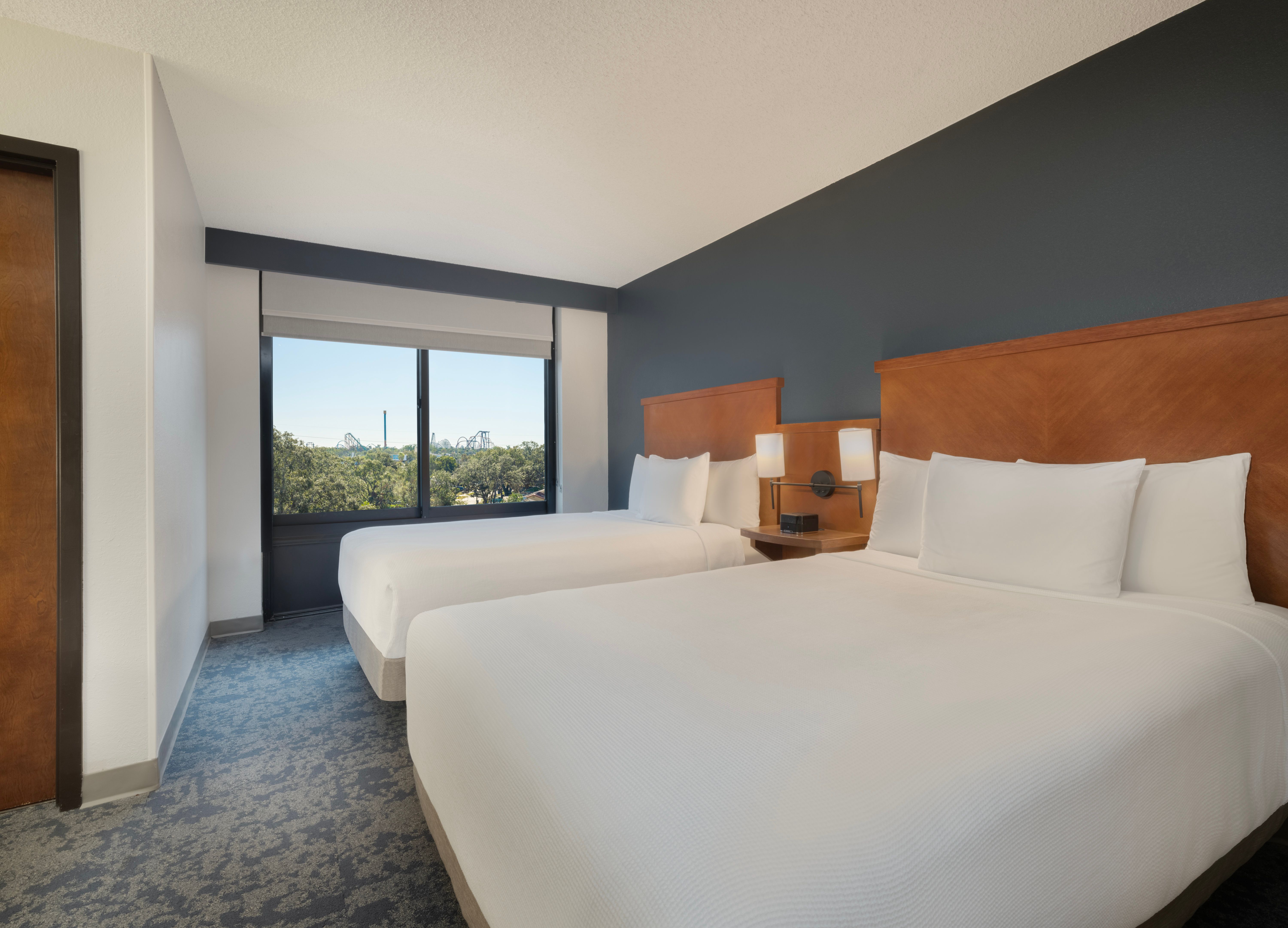 Hotel room at Hyatt Place Lakeland, with two queen beds, grey accent walls and wooden headboards